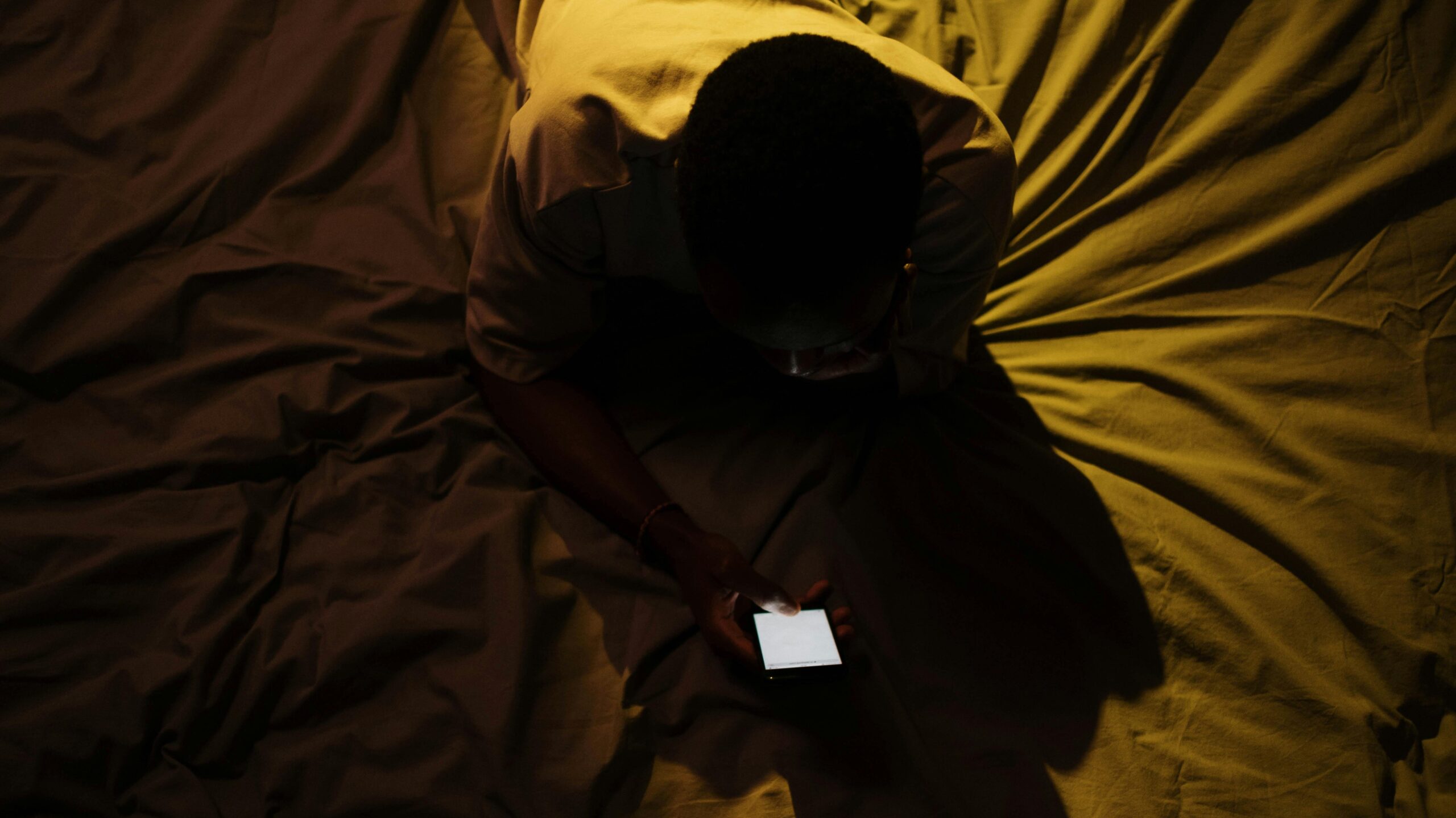 Man addicted to porn using phone on the bed