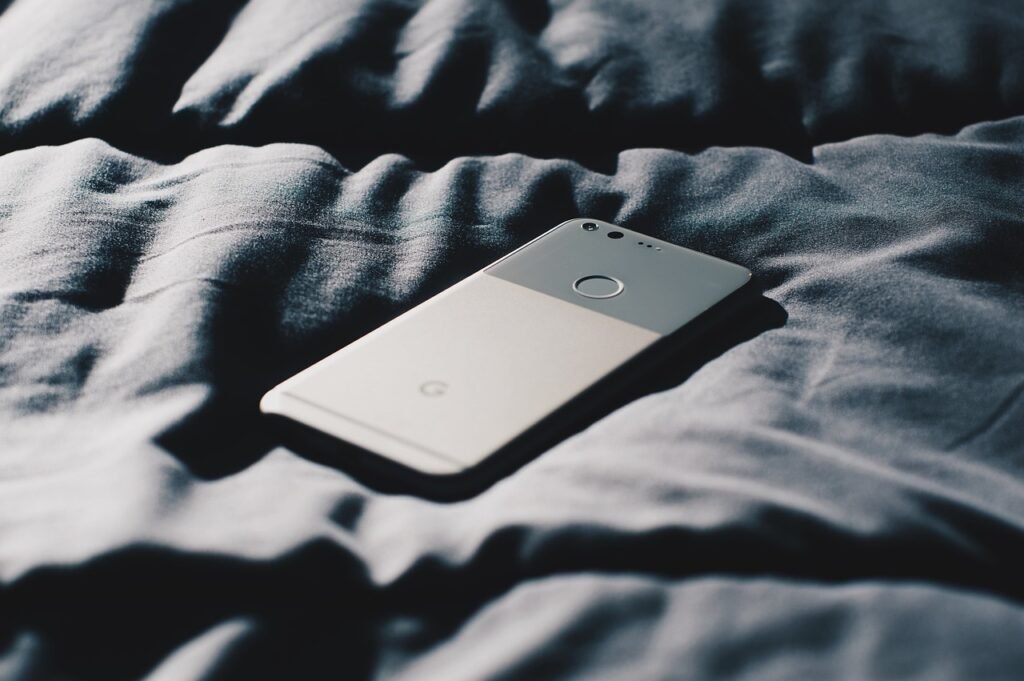 mobile phone on bed used for watching porn which fuels porn addiction